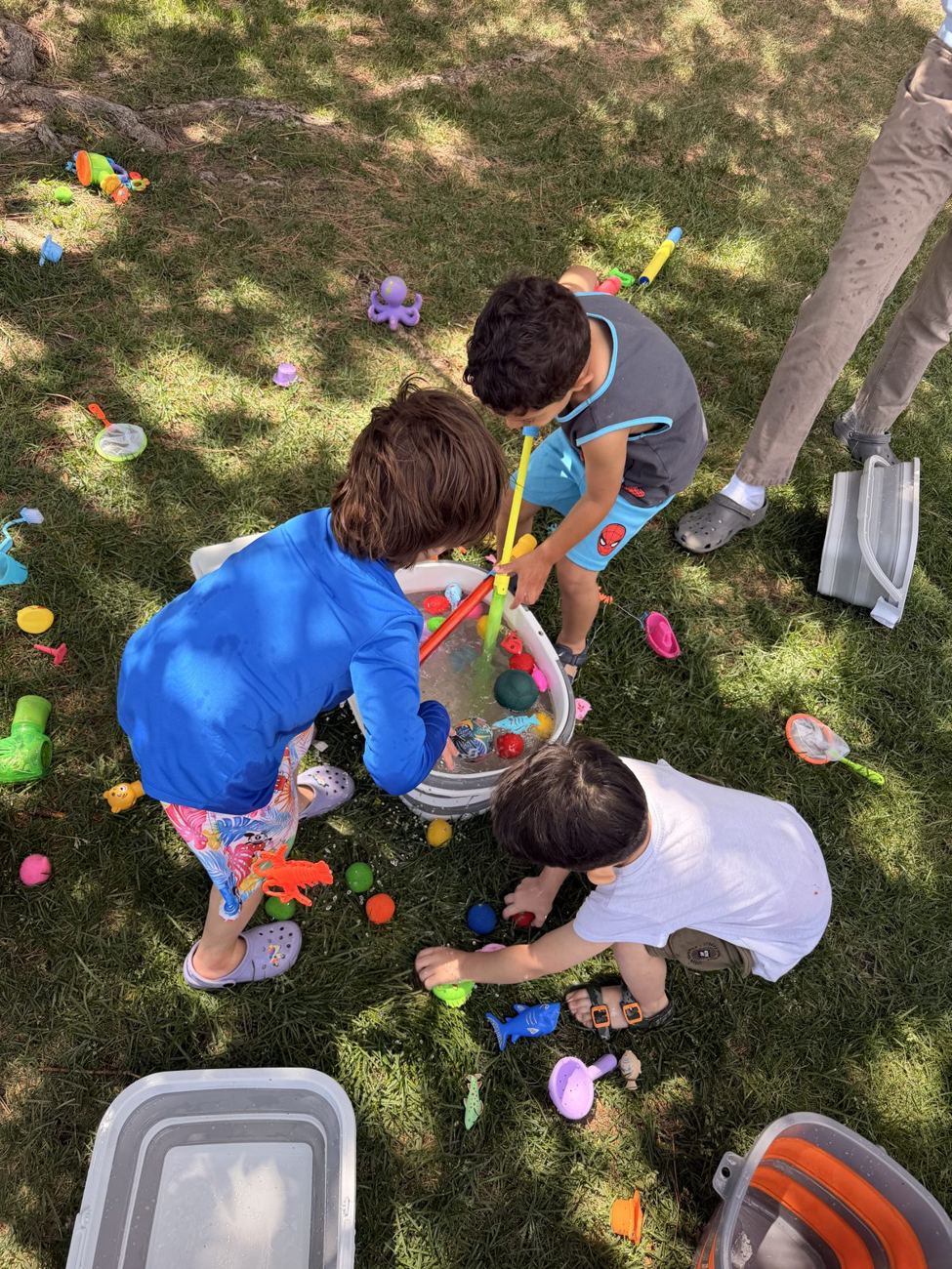 Children playing outdoors with water and toys
